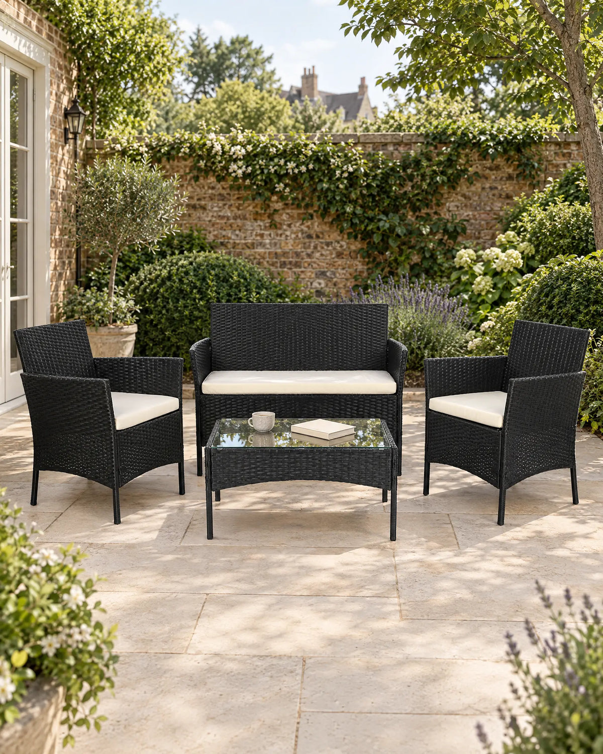 Black rattan garden sofa set arranged on a sunny British garden patio