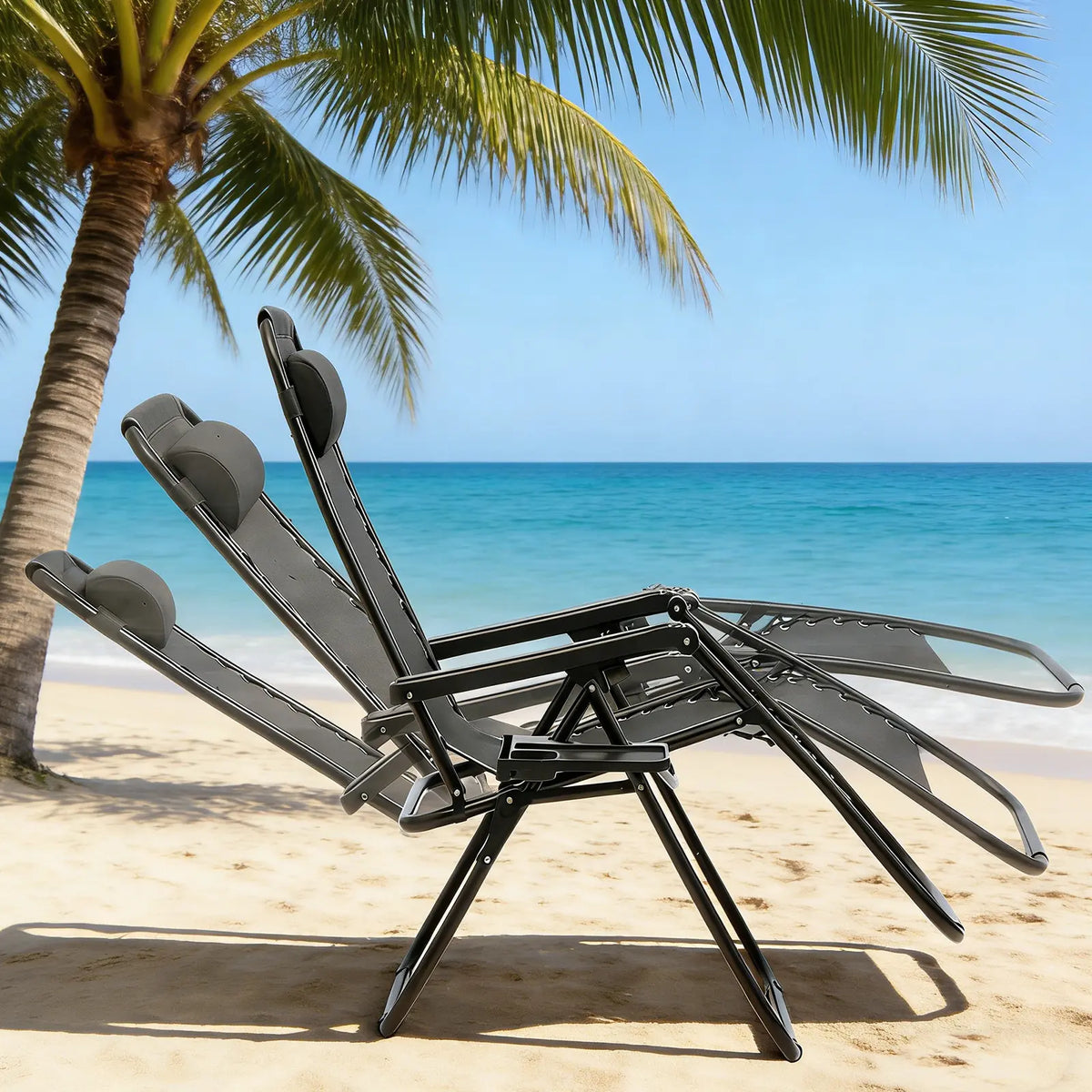 Two black zero-gravity reclining chairs shown in a fully reclined position on a tropical beach