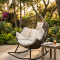 Grey rattan rocking chair styled in a cosy garden