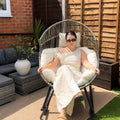 Oversized Egg Rattan Rocking Chair in a contemporary British garden with premium cushions and comfortable outdoor seating.