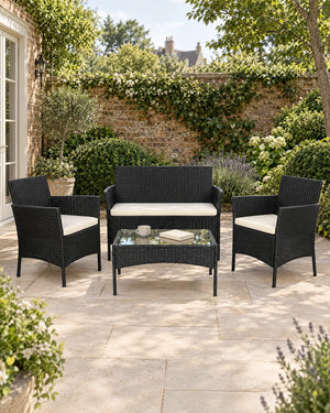 Black rattan garden sofa set arranged on a sunny British garden patio